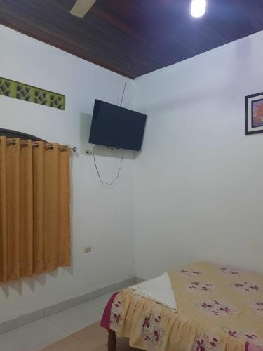 a bedroom with a bed and a tv on the wall at Hospedaje Sadicita in Requena