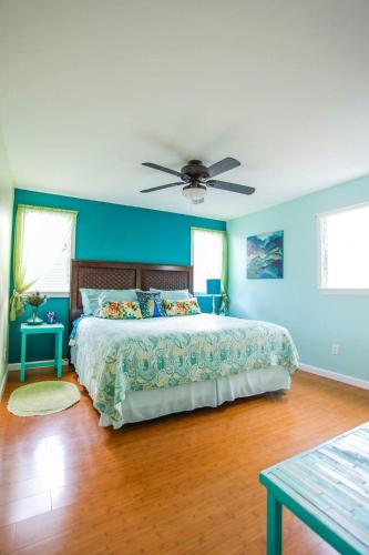 a bedroom with a bed with blue walls and a ceiling at Hale Mapuana in Pahoa