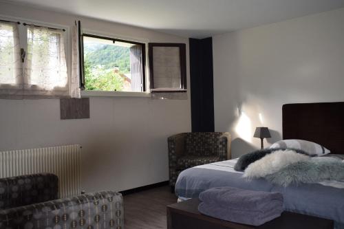 a bedroom with two beds and two chairs and a window at Appartement Le 510 in Aigueblanche