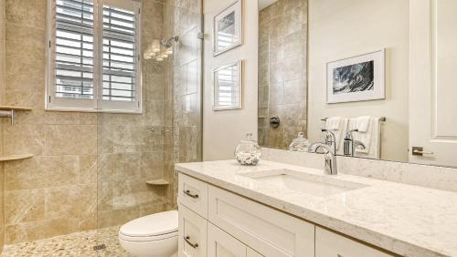 a bathroom with a sink and a toilet and a mirror at Casa Junonia - 1032L in Siesta Key