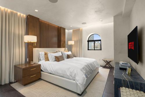 Luxury Penthouse with Empire State Views in NYC في نيويورك: غرفة نوم بها سرير أبيض كبير ونافذة