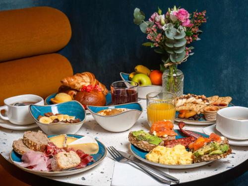 Una mesa cubierta con platos de desayuno y bebidas. en Mercure Annecy Centre, en Annecy