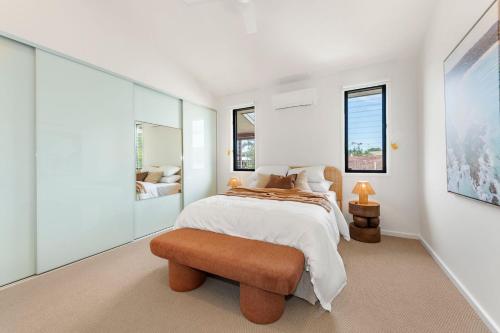 バイロンベイにあるKeesing Villa 8の白いベッドルーム(ベッド1台、スツール付)