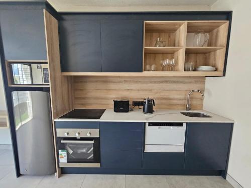 a small kitchen with blue cabinets and a sink at PinotageLuxuryCollection 14 Bastmolen in Stellenbosch