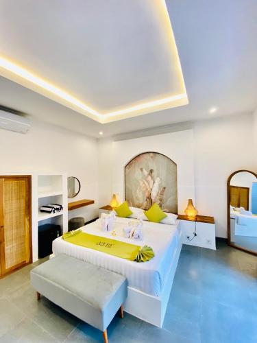 ein Schlafzimmer mit einem großen Bett mit gelben Kissen in der Unterkunft Azure Suites in Dalung