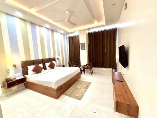 ein Schlafzimmer mit einem Bett und einem Fernseher darin in der Unterkunft Murthal Green Plaza Hotel in Sonīpat