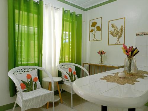 een eetkamer met een witte tafel en stoelen bij Liberty's Homestay in Coron