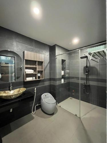 a bathroom with a toilet and a sink and a shower at Thiên long homestay in Kinh Dinh