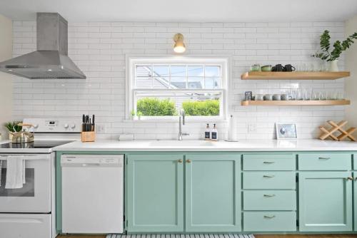 麦克明维尔Happy House - Near 3rd Street wine getaway的厨房配有蓝色橱柜和窗户。