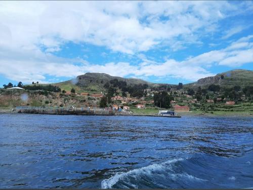 a large body of water with mountains in the background at Misky Wasi lodge Occosuyo in Puno