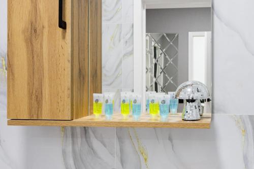 Un estante con botellas de detergente y un espejo. en Мягкое гнёздышко с креслом у Хан-Шатыра, en Astana