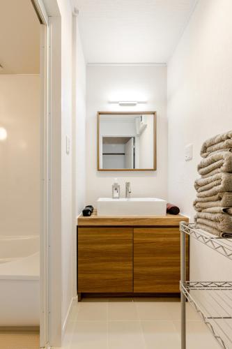 a bathroom with a sink and a mirror at Leaf and Light Dazaifu in Dazaifu