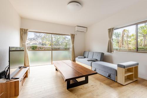 a living room with a couch and a table at Leaf and Light Dazaifu in Dazaifu