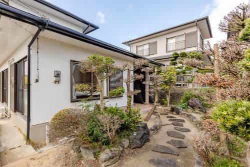a house with a garden in front of it at Leaf and Light Dazaifu in Dazaifu