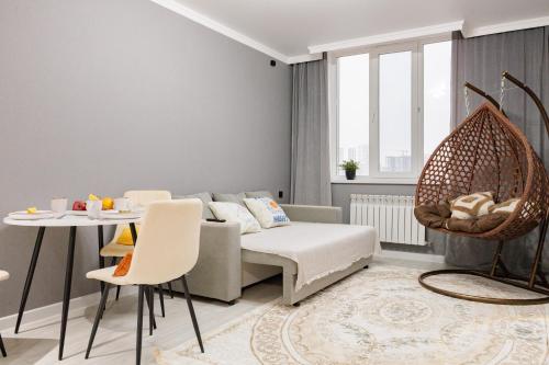 una sala de estar con un sofá y una mesa en Мягкое гнёздышко с креслом у Хан-Шатыра, en Astana