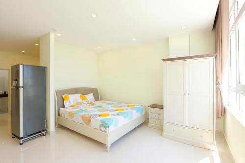 Un dormitorio pequeño con una cama y un refrigerador. en Victoria Hotel And Apartment, en Ga Tân Thiết