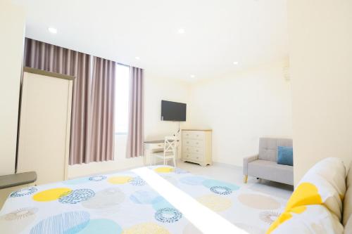 une chambre avec un lit, un bureau et une télévision dans l'établissement Victoria Hotel And Apartment, à Ga Tân Thiết