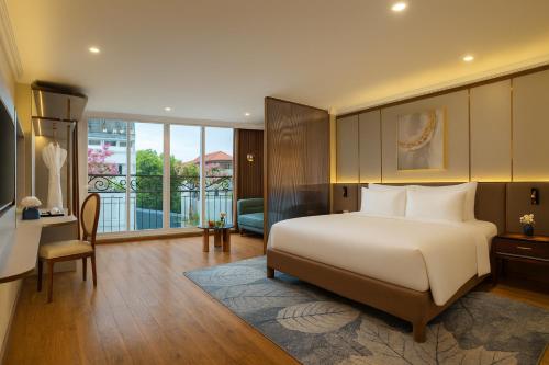 a bedroom with a large white bed and a desk at Splendid Secret Hotel in Hanoi