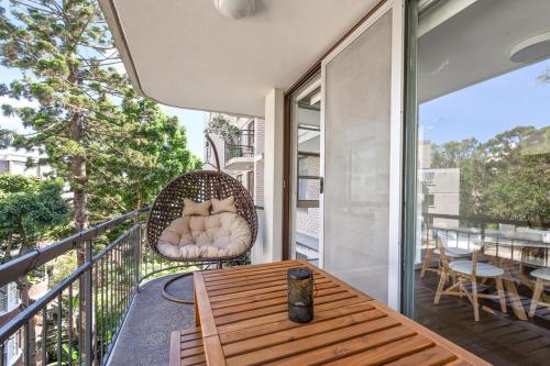 a balcony with a wooden table and a chair at Stylish City Stay, Elizabeth Bay 2BR, Pool, balcony in Sydney