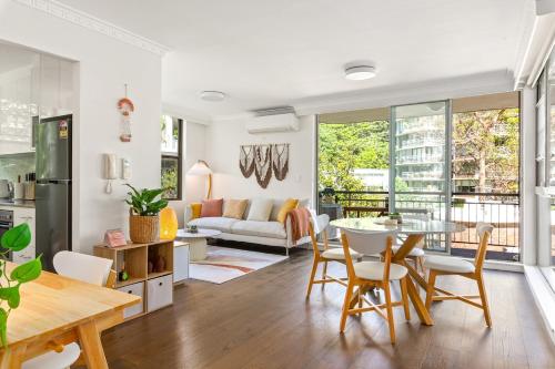 a kitchen and living room with a table and chairs at Stylish City Stay, Elizabeth Bay 2BR, Pool, balcony in Sydney