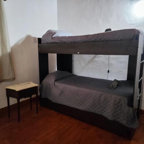een slaapkamer met twee stapelbedden en een tafel bij Los EU in Puerto Iguazú