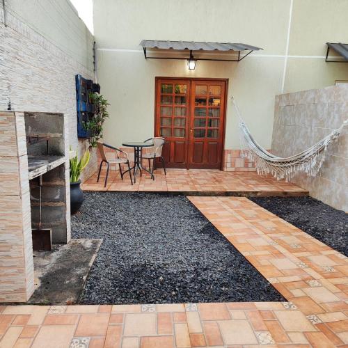 Un patio con una mesa y sillas frente a un edificio. en Los EU, en Puerto Iguazú