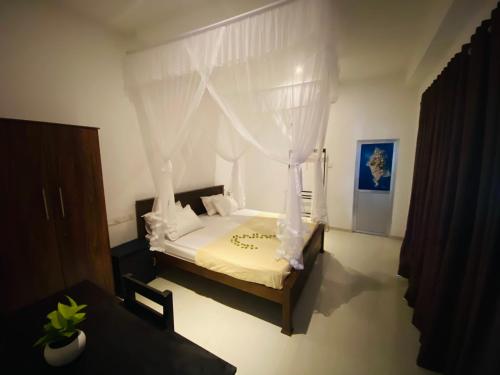una camera da letto con un letto bianco con baldacchino di Seoul Beach Mirissa a Mirissa