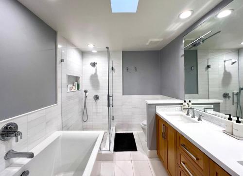 a bathroom with a tub and a shower and a sink at Malibu Waterfront Gallery with Private Beach Access in Malibu Beach