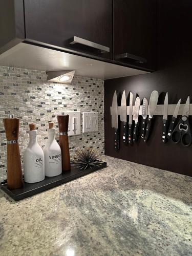 a kitchen counter with bottles and knives on a shelf at 2Level Duplex with Jaccuzi-Gem in Chicago 4BD&3BA in Chicago