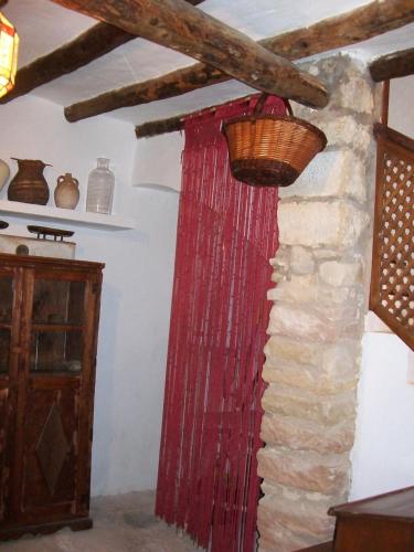 a room with a red curtain and a basket on a wall at Casa de la Musica in Calaceite