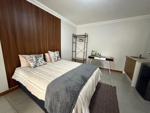 a bedroom with a large bed and a table at The Minimalist Suite in Kempton Park
