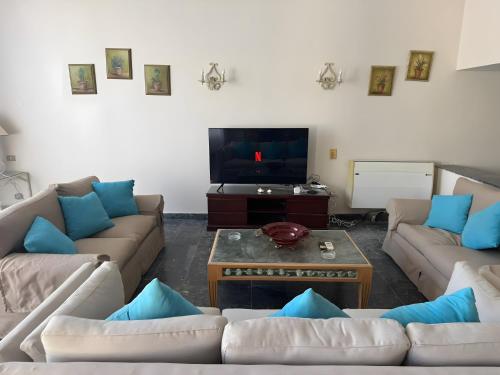 a living room with couches and a flat screen tv at 4 Bedroom Seaside Hurghada Escape in Hurghada