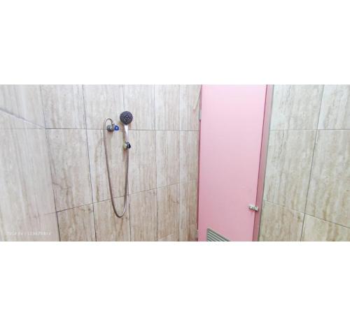 una ducha con cabezal de ducha en un baño en OYO 95042 Jasmine Guest House, en Karangtengah