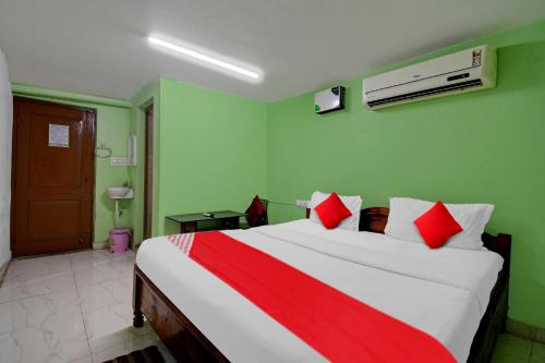 a bedroom with a large bed with red and white pillows at Hotel O A1 Residency in Bhubaneshwar