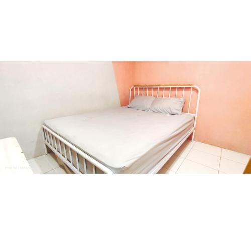 Cama en habitación con colchón blanco en OYO 95042 Jasmine Guest House, en Karangtengah