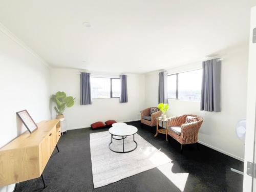a white living room with a table and chairs at Dove's Rest-Brand New 4 Bedrooms Getaway to Eden in Hamilton