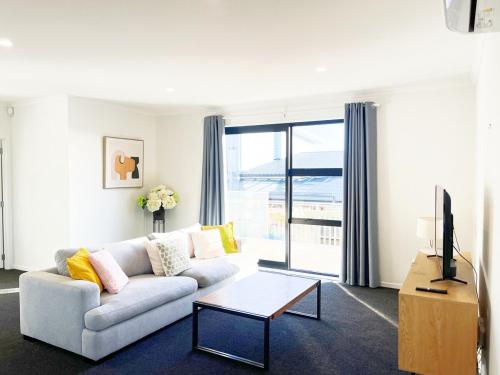 a living room with a couch and a tv at Dove's Rest-Brand New 4 Bedrooms Getaway to Eden in Hamilton