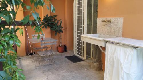 a bathroom with a sink and a table and a plant at Relais Pacinotti Apartments in Pisa