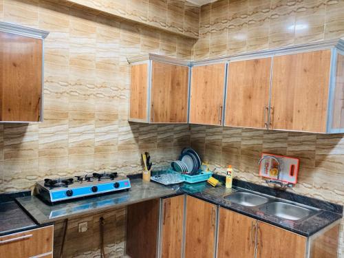 a kitchen with wooden cabinets and a blue stove at Terhal guest house in Muscat