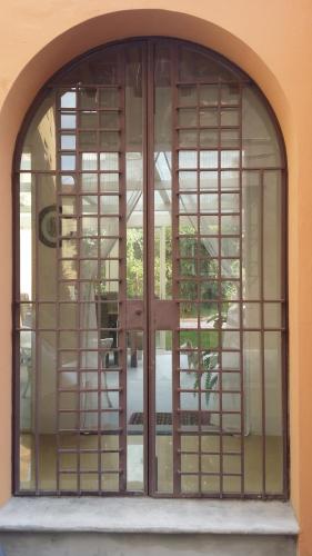 an arched window with a door in a building at Relais Pacinotti Apartments in Pisa