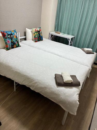 a large white bed with two towels on it at SJins in Tokyo