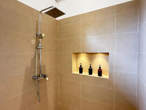 a bathroom with a shower with three bottles of wine at Lily Mirissa in Mirissa