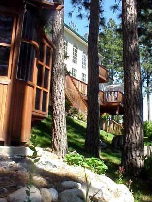 a tree house with a deck in a yard at River Cove Elegant Waterfront Bed & Breakfast in Post Falls