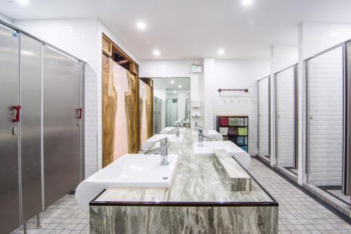 a bathroom with three sinks and a row of mirrors at Nonze Hostel in Pattaya Central