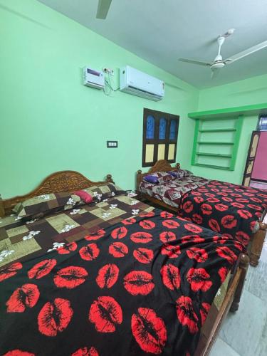 1 Schlafzimmer mit 2 Betten mit einer schwarzen und roten Decke in der Unterkunft CR Residency in Tiruvannāmalai