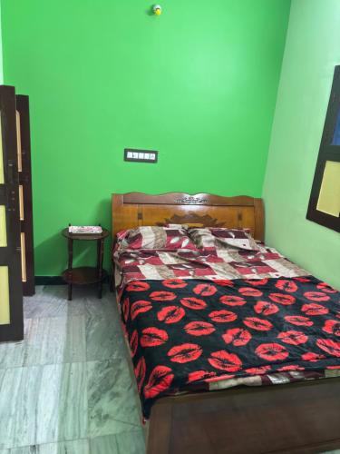 Bett in einem Zimmer mit grüner Wand in der Unterkunft CR Residency in Tiruvannāmalai