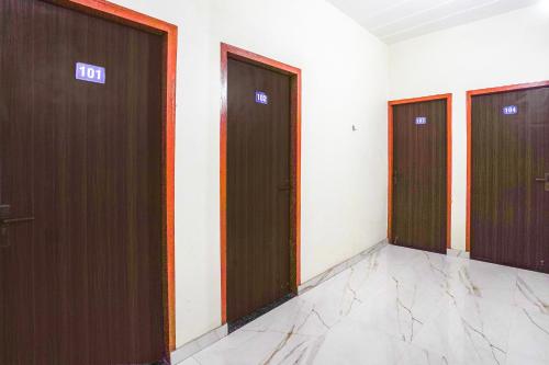 uma fileira de elevadores em um prédio com portas marrons em Hotel O A G M Residency em Sohna