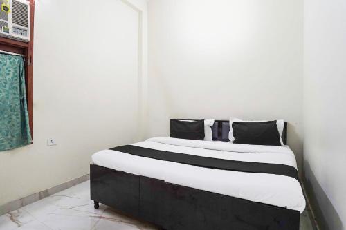 een bed met zwart-witte kussens in een kamer bij Hotel O Madhur Milap in Sohna