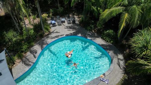 an overhead view of people swimming in a swimming pool at Bayshore Bungalow 8 - Oceanstays in Byron Bay