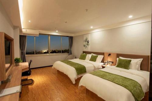 a hotel room with two beds and a window at GreenTree Inn Express Shandong Zaozhuang Shizhong District Huashan Road Ginza in Zaozhuang
